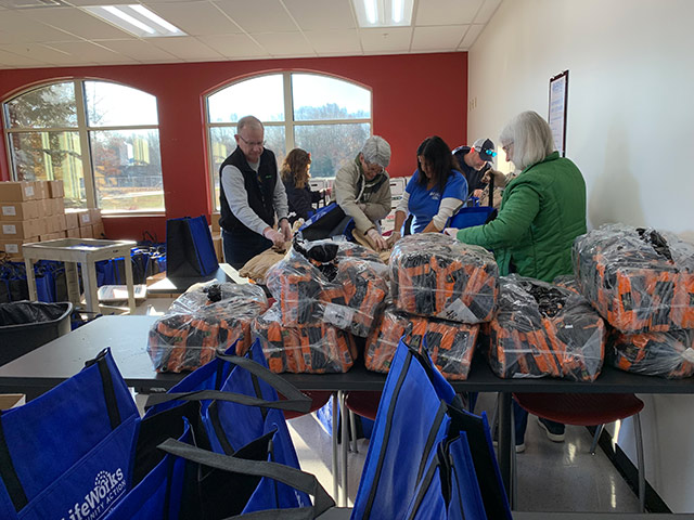 Group of BSNB volunteer employees packing bags at Lifework's Community Action.